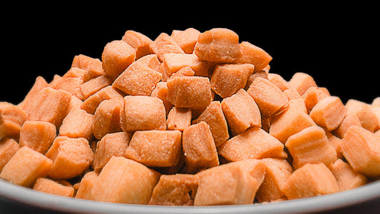 Golden brown chin-chin pieces against a black background, highlighting the crisp texture of the Nigerian snack.
