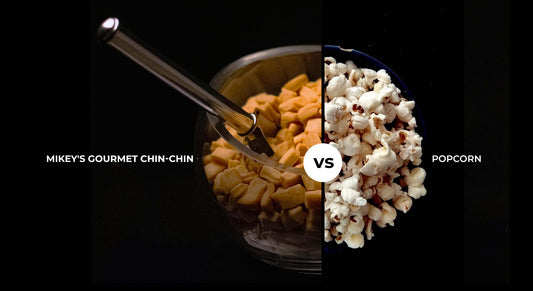 A half and half bowl of Mikey's Gourmet Chin-Chin and Popcorn with a caption that reads Mikey's Gourmet Chin-Chin vs. Popcorn 