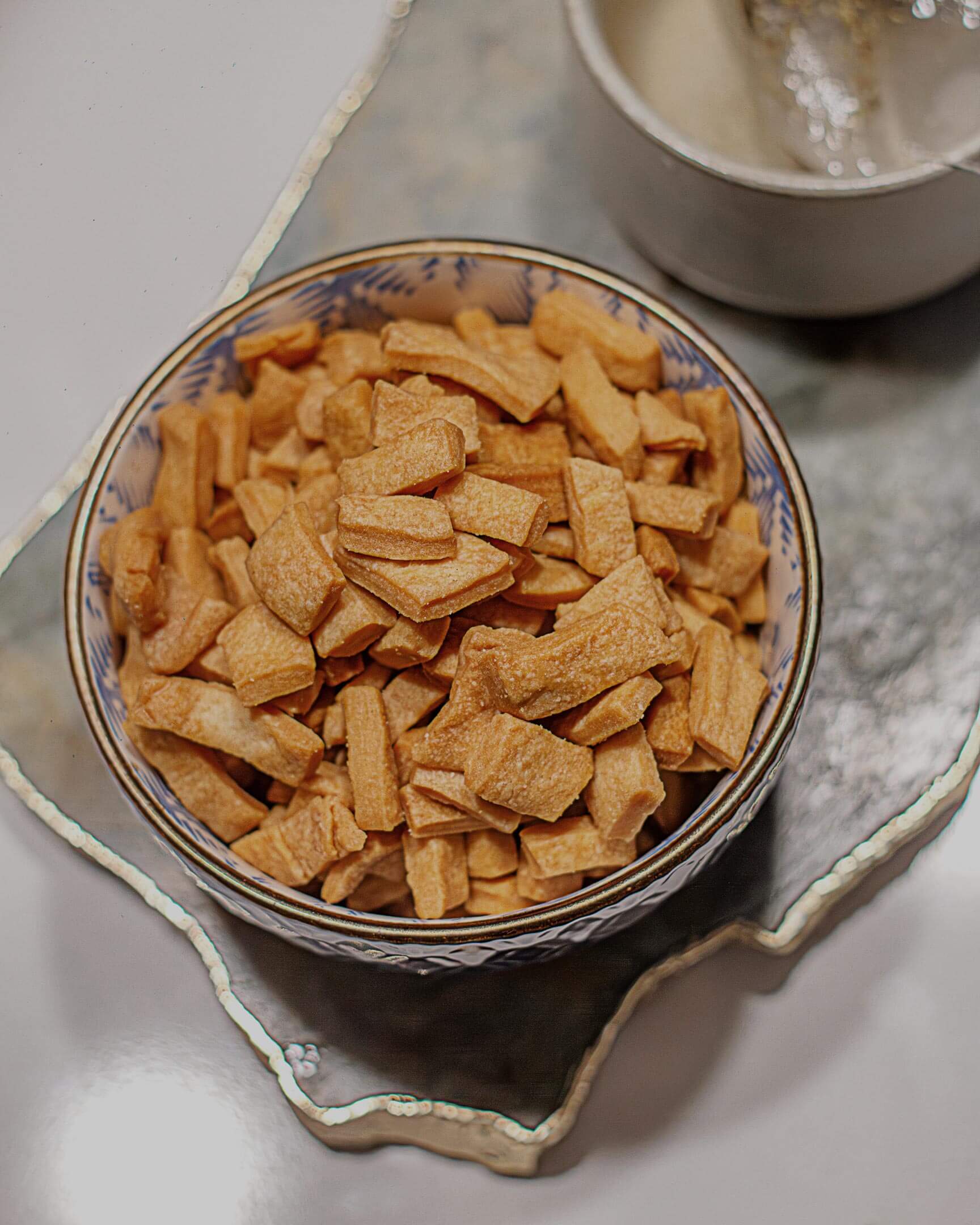 Mikey's Gourmet Chin-Chin in a bowl and a cup of tea