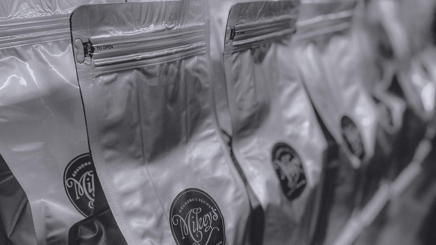 Rows of sealed Mikey's Gourmet Chin-Chin bags lined up in silver, ready for batch shipment.